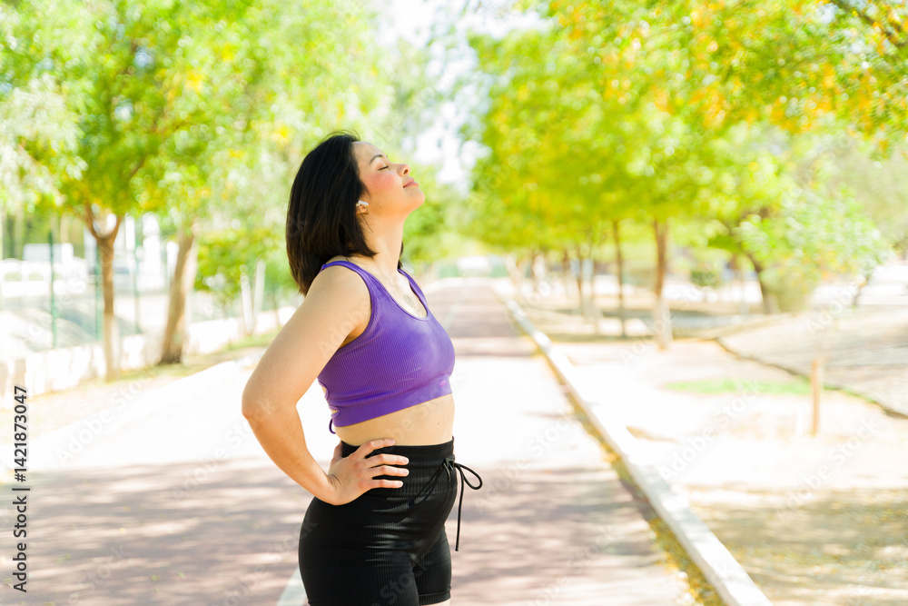 Runner taking deep breath while resting after workout in park