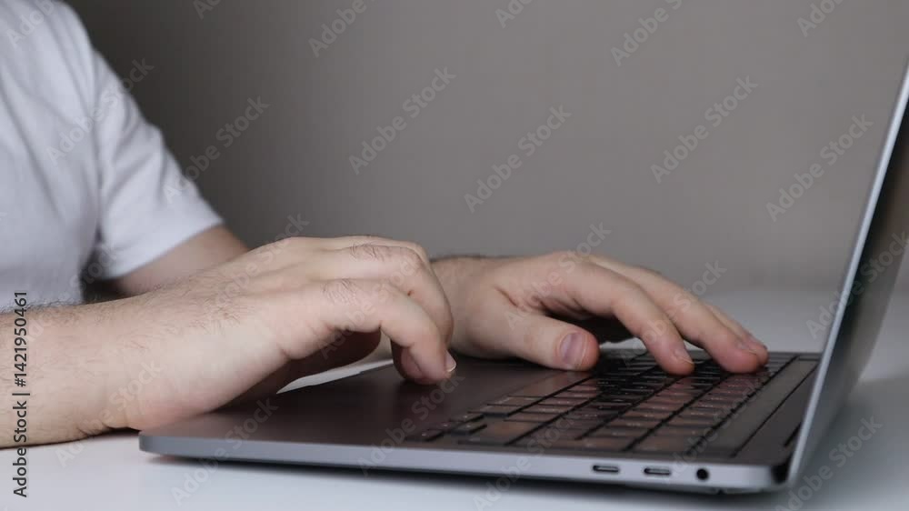 Close-up of hands typing on a laptop keyboard in a minimalist workspace Close-up of hands typing on a laptop keyboard in a minimalist workspace
