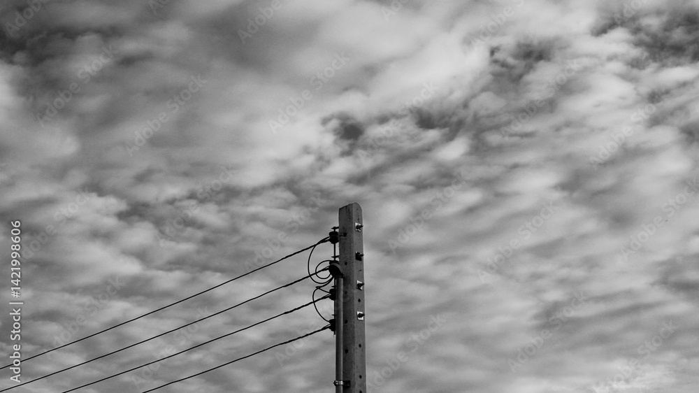 Fototapeta premium Black image of power pole and sky clouds background with grainy texture. Abstract black background from nature. Darkness, fine art, electricity, power line, lonely, city concept for wallpaper, print.