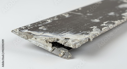 Closeup of Bent Gray Metal Putty Knife Blade with White Residue on White Background