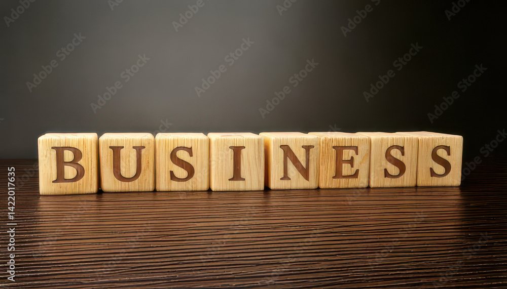Fototapeta premium Wooden blocks spelling word BUSINESS on wooden surface