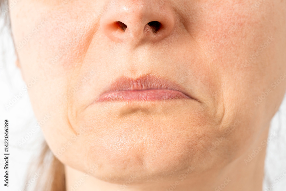 Obraz premium Face without makeup. Mouth with pursed lips expressing negativity, disapproval, mimic wrinkles