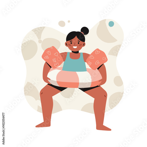 Girl wearing inflatable armbands and swim ring ready for swimming pool fun in summer season 