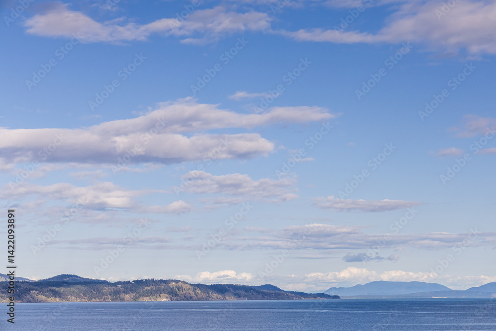 Obraz premium Beautiful Coastal View with Clouds and Horizon on a Calm Ocean Day