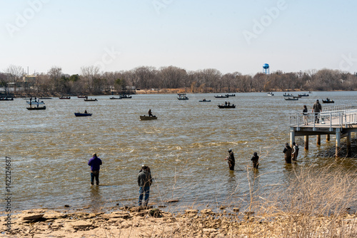 Obraz na płótnie People fishing in boats and on the river shoreline on Fox river in Spring at De Pere, Wisconsin w salonie