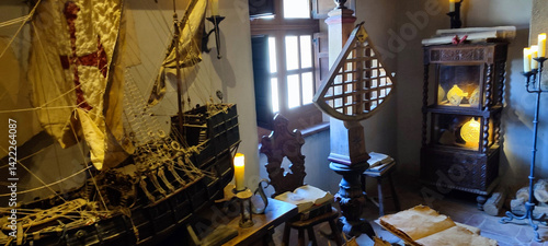 Foto Maritime museum exhibit displaying detailed Spanish galleon model with billowing sails alongside antique navigation instruments