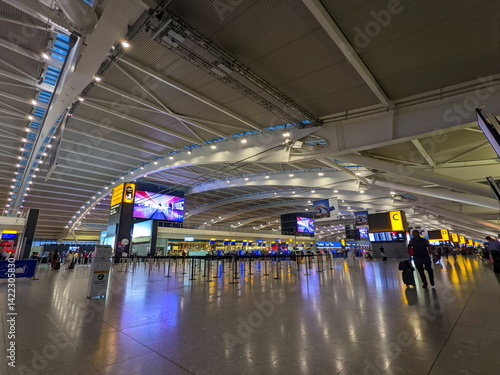Travelers and staff navigate the modern, spacious Heathrow Airport Terminal 5 departure area in London