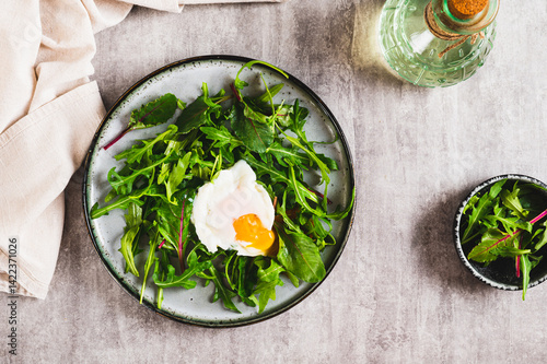 Obraz na płótnie Poached egg in arugula and chard leaves on a plate on a table top view w salonie