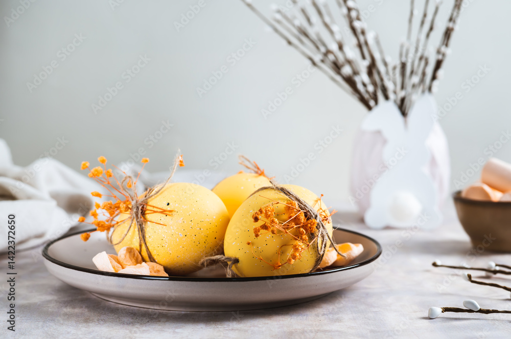 Easter decorations, decorated eggs on a plate, bunny and willow on the table