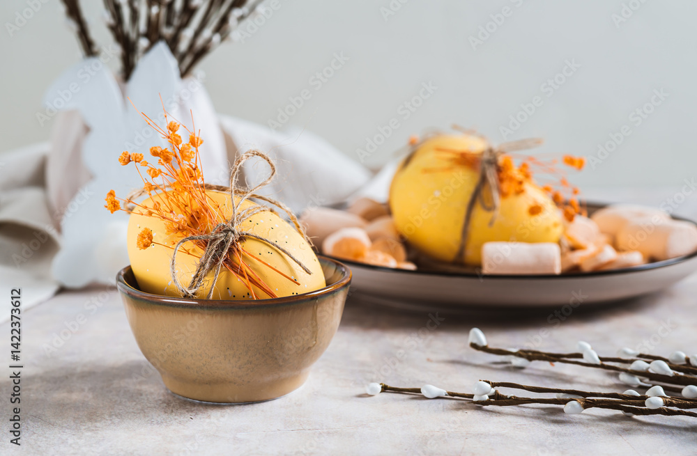 Easter egg with dried flowers in a bowl and willow on the table