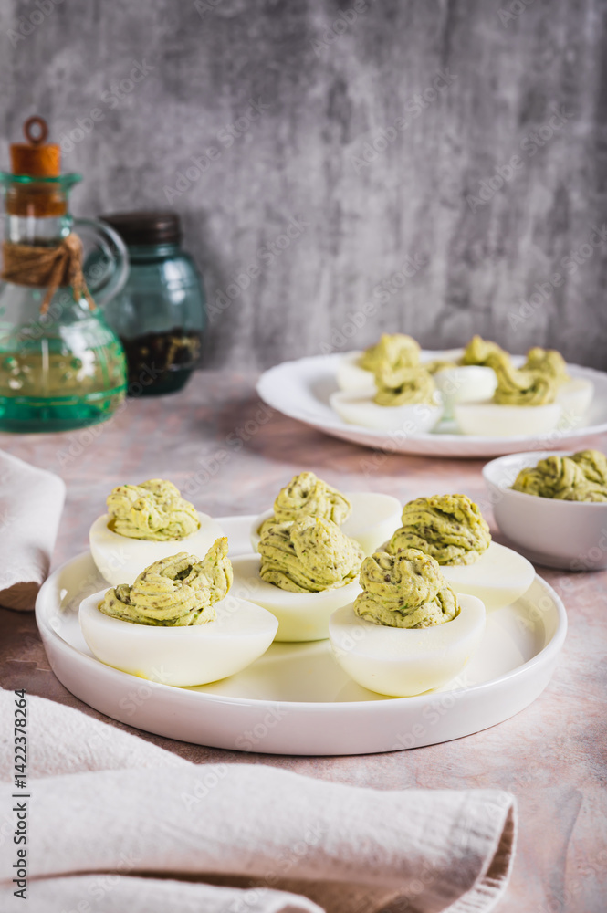 Eggs stuffed with avocado and yolk mixture on a plate on a table vertical view
