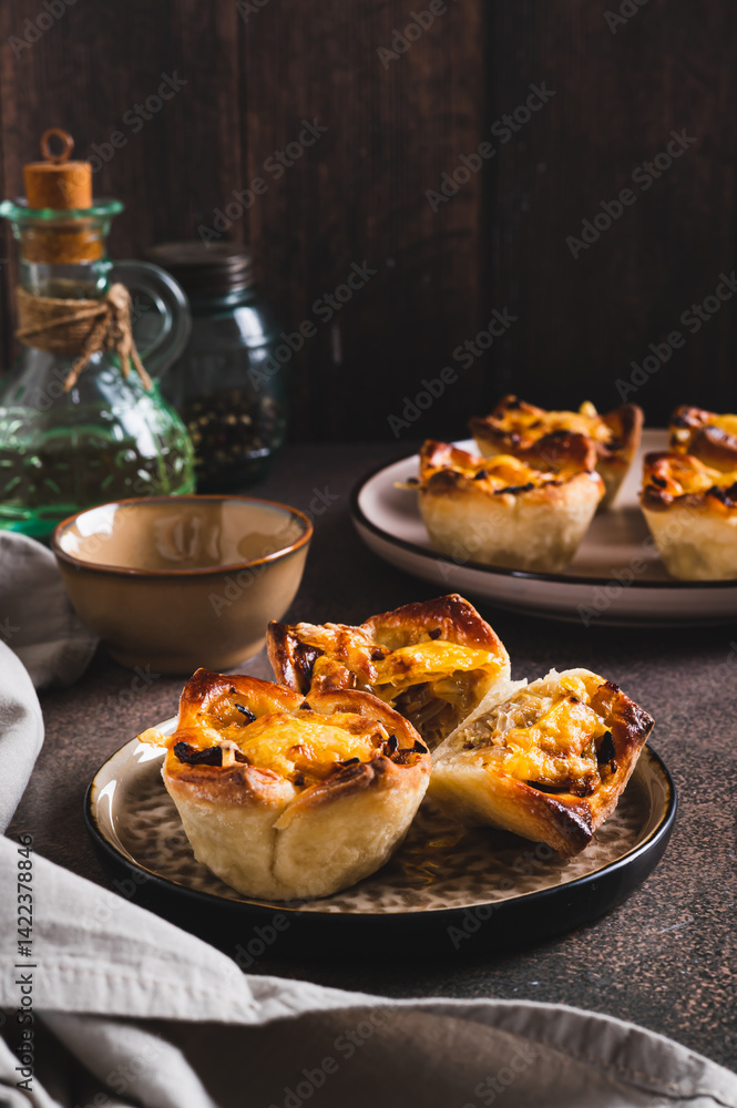 Mini tartlets with caramelized onions and cheese on a plate on a table vertical view