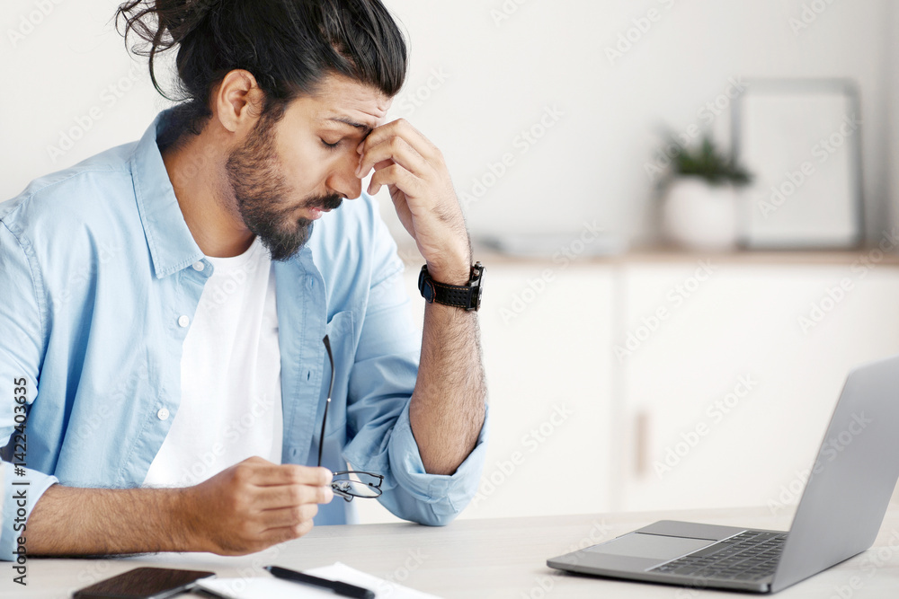 Eyes Fatigue. Stressed Indian Freelancer Man Tired After Working On Laptop Computer In Home Office, Massaging Nosebridge,Taking Off Glasses, Having Headache Or Problems At Work, Free Space Eyes Fatigue. Stressed Indian Freelancer Man Tired After Working On Laptop Computer In Home Office, Massaging Nosebridge,Taking Off Glasses, Having Headache Or Problems At Work, Free Space