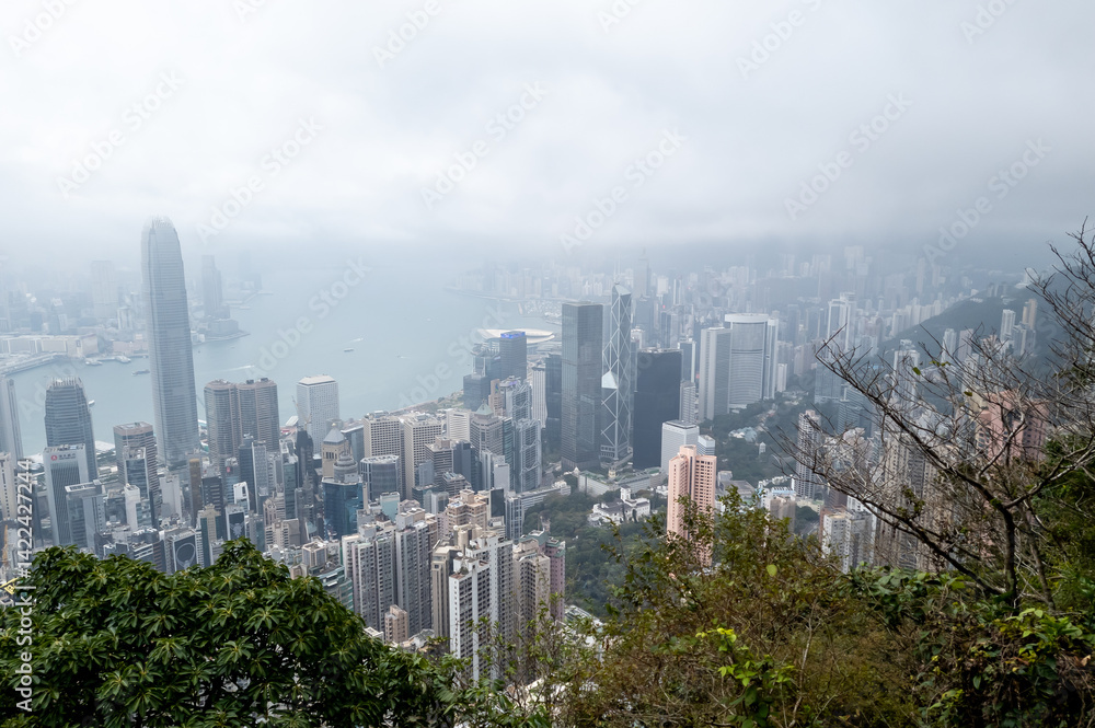 Fototapeta premium Hong Kong. China- 03.01.2025. A mountain view of the Hong Kong island city sky line showing the many skyscrapers on a very misty day.