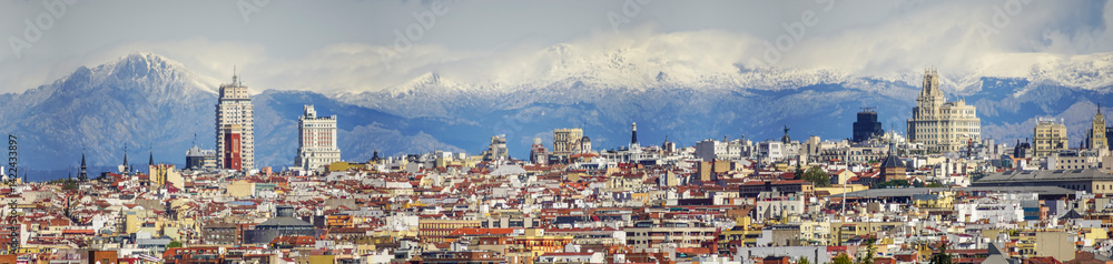 Obraz premium Panoramic view of Madrid, the capital of Spain, with the partially snow-covered mountains in the background.