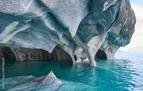 Interior of the flooded Marble Caves, unique rock formations in the General Carrera Lake, Chile. The walls of the caves have swirling mineral patterns. Turquoise water fills the caves with blue light.