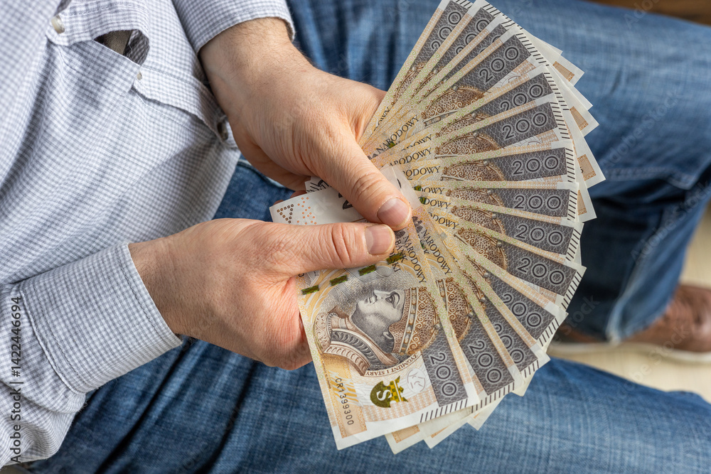 Poland Money. Man holding a fan of 200 zloty banknotes in his hand. Financial concept. Business symbol