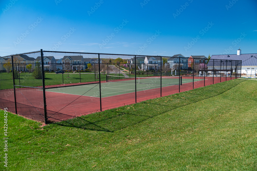 Fototapeta premium Tennis court on a residential development with rows of single family homes.