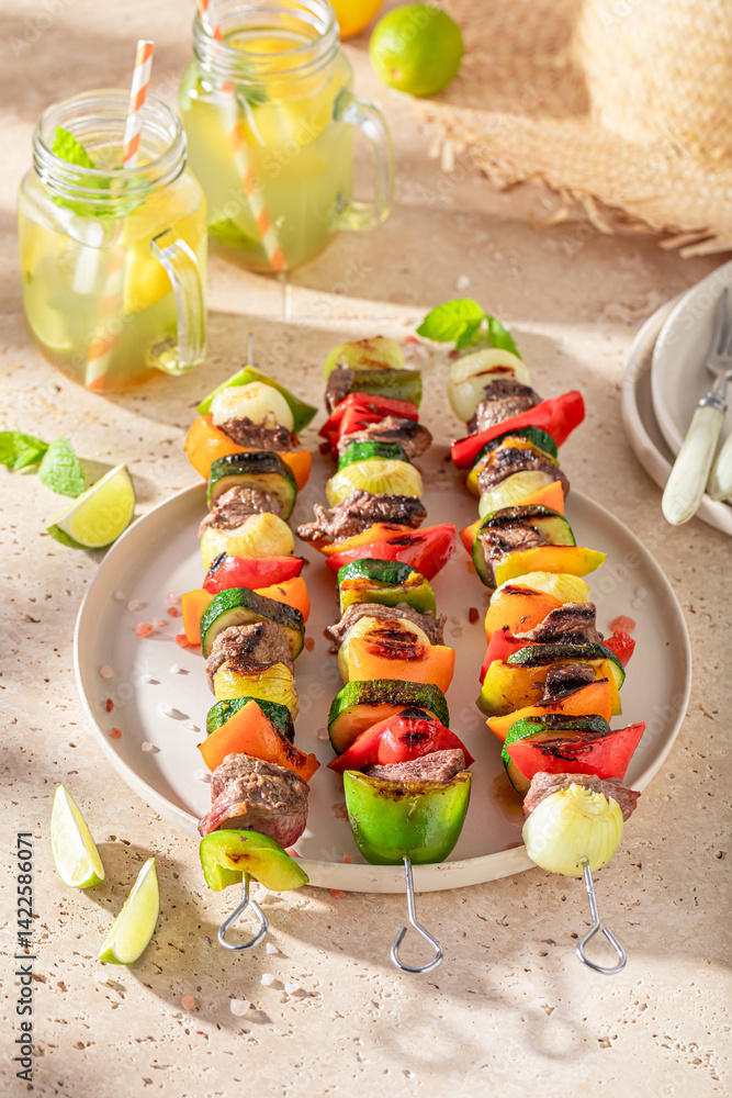 Tasty roasted skewer served with lime and herbs.