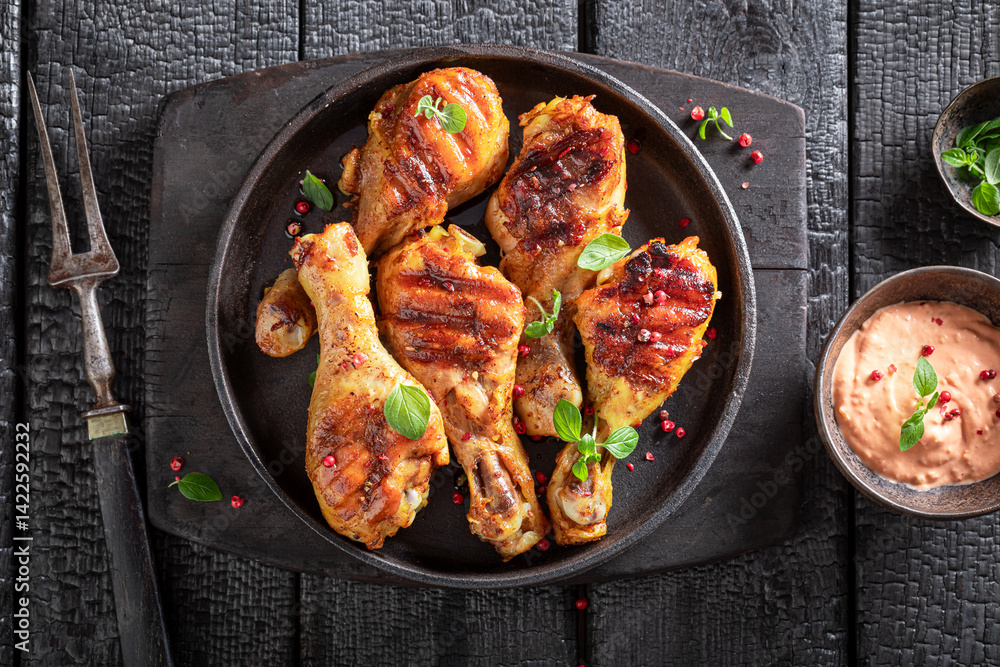 Tasty roasted chicken leg as summer delicacy in sunny day.