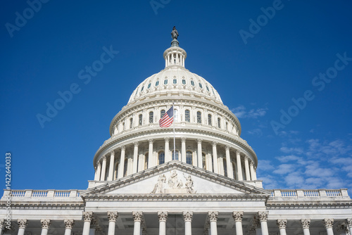 The United States Capitol dome against a clearing blue sky viewed from the east front of the U.S. Capitol building in Washington, DC.