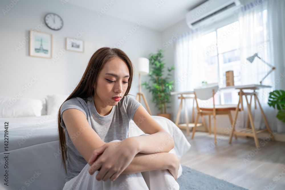 Depressed Asian woman feel upset while sitting alone on bed in bedroom. Depressed Asian woman feel upset while sitting alone on bed in bedroom.