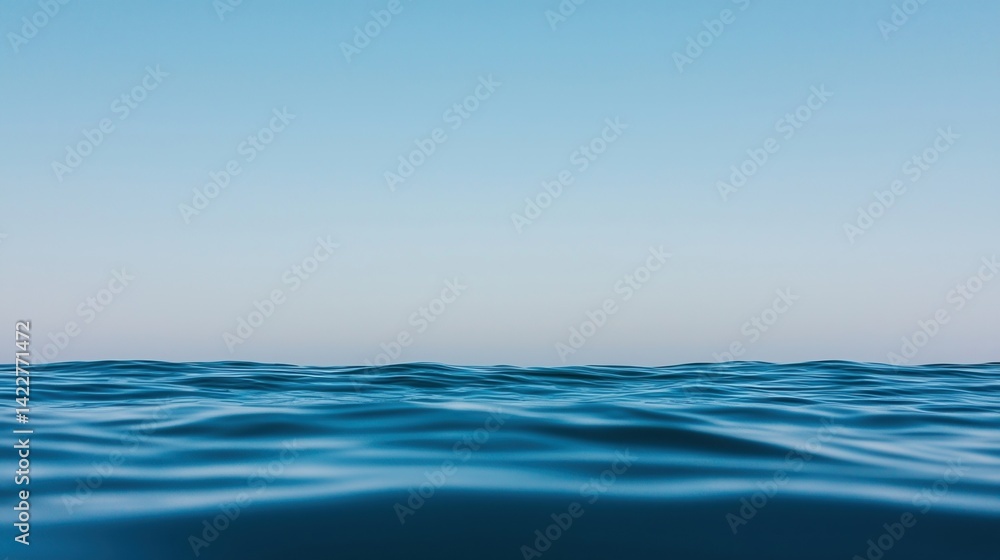 Obraz premium Serene ocean view with gentle waves under a clear blue sky, creating a peaceful and calming atmosphere.