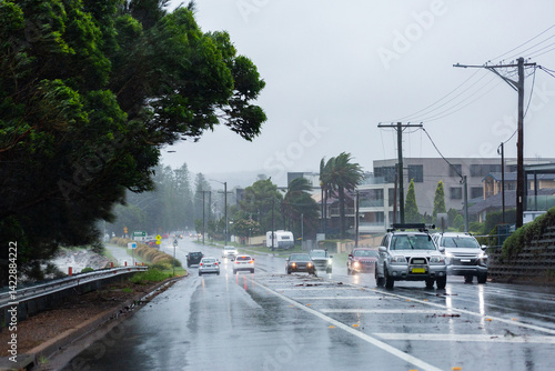 Cars traveling on slippery wet coastal road on windy rainy day in Newcastle