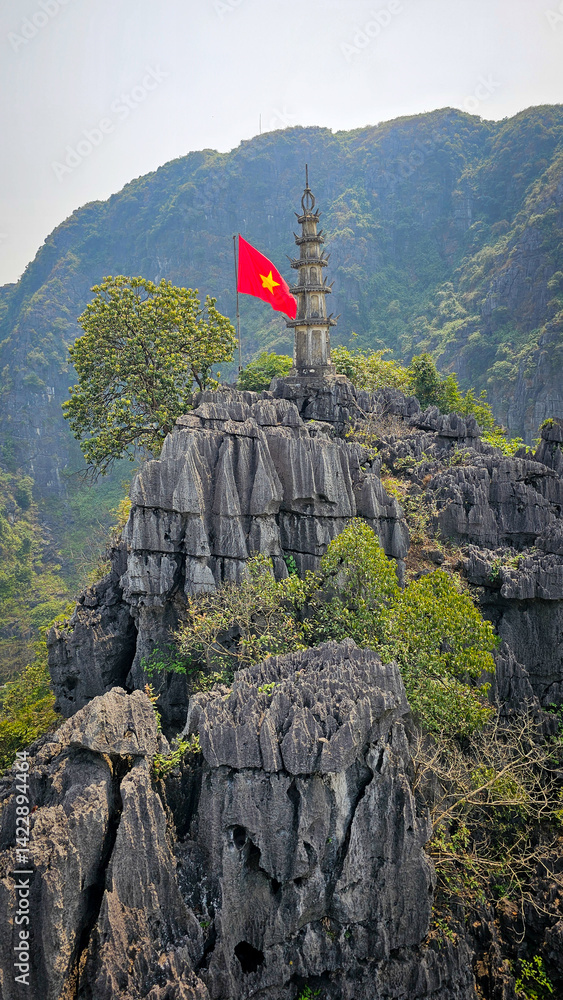 Naklejka premium Vietnam flag with mountain top temple and limestone cliffs