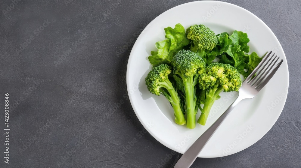 Plate of healthy green broccoli centered between fork and knife for diet and vegan visuals Plate of healthy green broccoli centered between fork and knife for diet and vegan visuals