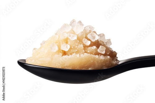 A spoonful of light brown, grainy substance speckled with crystalline pieces.