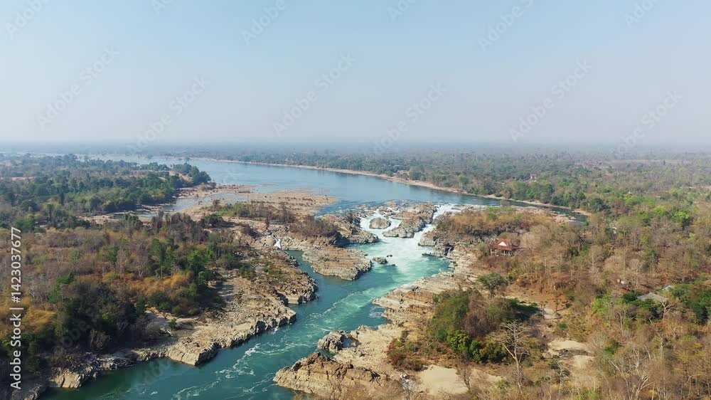 Khone Falls in the middle of the countryside and the waters of the Mekong River in Asia, Laos, Champasak, 4000 Islands, Don Det, on a sunny day. Khone Falls in the middle of the countryside and the waters of the Mekong River in Asia, Laos, Champasak, 4000 Islands, Don Det, on a sunny day.