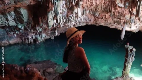 Happy young Asian woman enjoying holiday and scenery at Rangko Cave, Labuan Bajo, Indonesia.