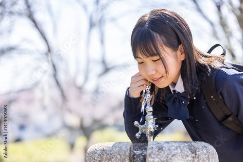 公園の水道で水を飲む女の子
