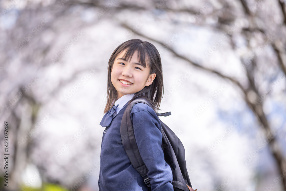 桜の下で微笑む学生