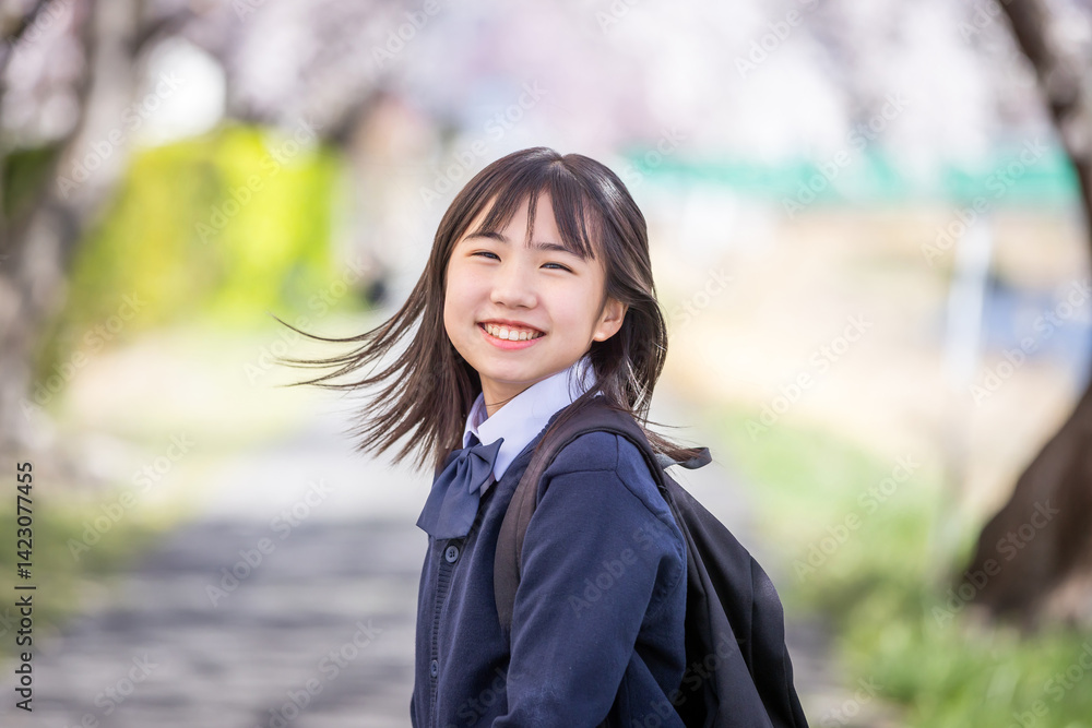桜の下で微笑む学生