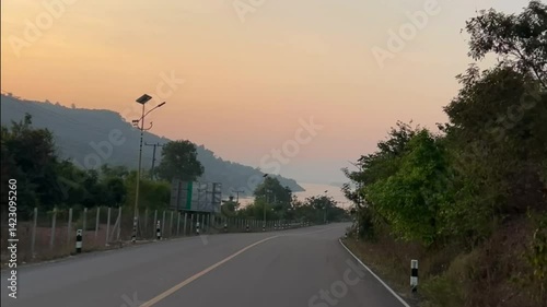 Asphalt road into vibrant sunset with Mekong riverside  landscape, vientiane, Laos, tourism in Asia