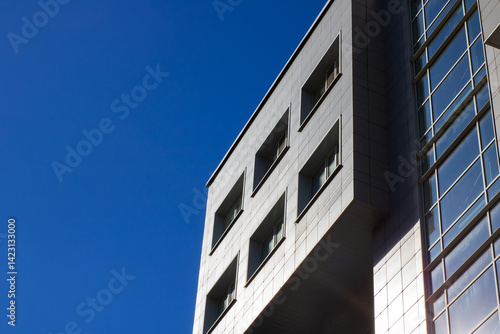Wallpaper Mural A tall building featuring numerous windows set against a clear blue sky Torontodigital.ca