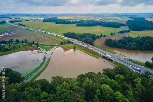 Obraz na płótnie Aerial view of flooded fields and submerged rural road near busy highway. Concept of climate impact, transportation disruption and natural disaster w salonie