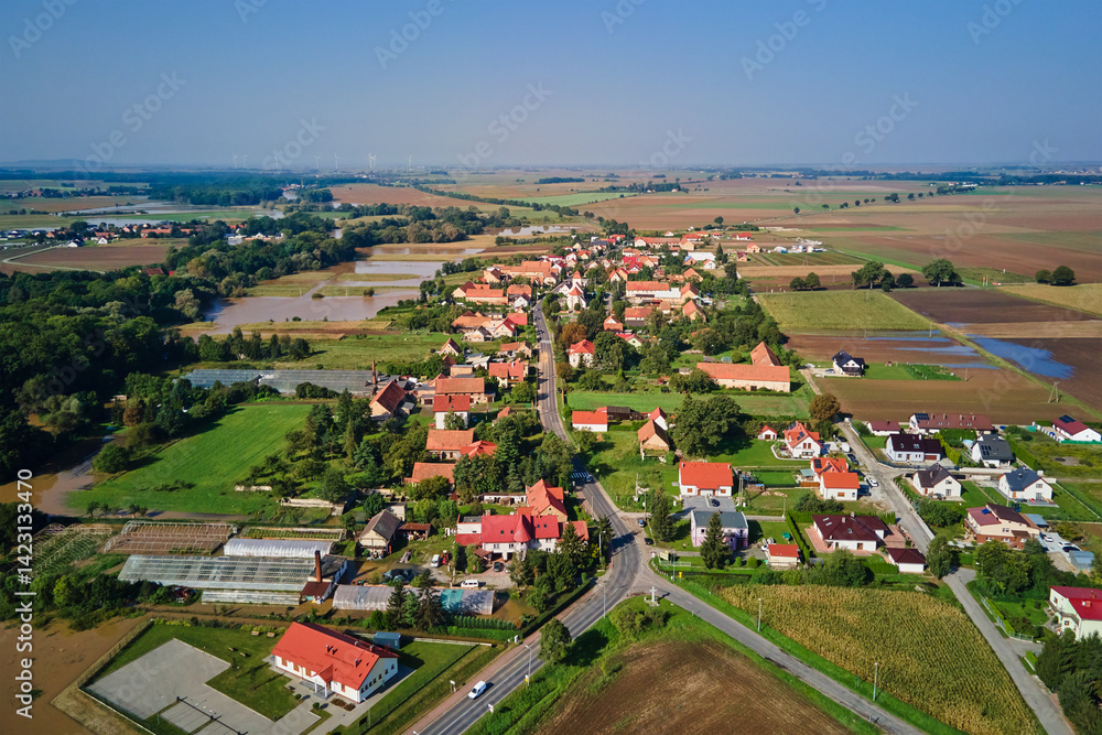 Aerial view of rural village, flooded fields and farmland. Countryside landscape after flooding