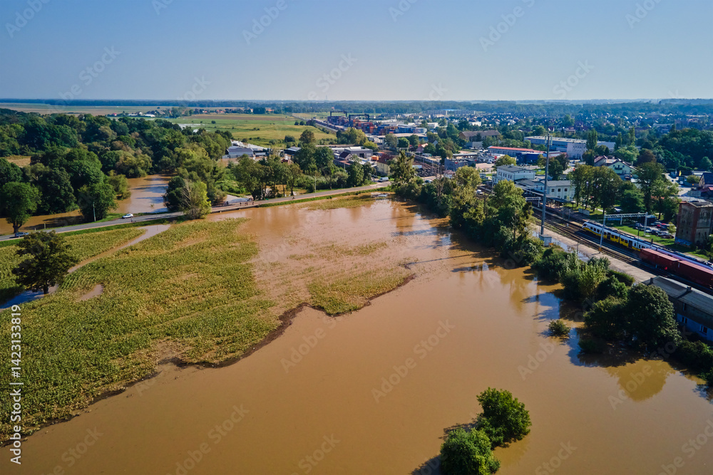 Aerial view of flooded streets, railway tracks and buildings in a suburban area. Industrial zone with floodwater after heavy rain. Concept of natural disaster, climate impact and emergency