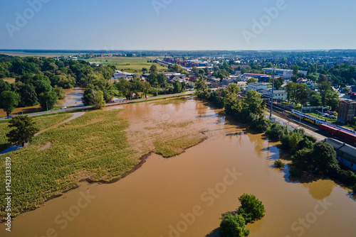 Obraz na płótnie Aerial view of flooded streets, railway tracks and buildings in a suburban area. Industrial zone with floodwater after heavy rain. Concept of natural disaster, climate impact and emergency w salonie