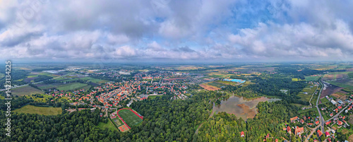 Obraz na płótnie Aerial view of small town surrounded by forest, farmland, and flooded areas after heavy rain. Bird eye view of village in Poland. Landscape with residential buildings in suburban neighborhood w salonie
