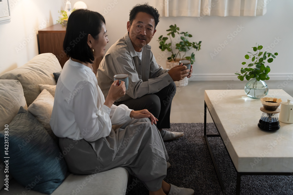 マグカップで飲み物を飲むミドル夫婦　ライフスタイルイメージ