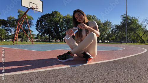 Obraz na płótnie Young exhausted woman drinking water after jogging and exercise in urban park. w salonie