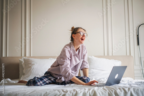 Beautiful smiling woman using laptop in bed