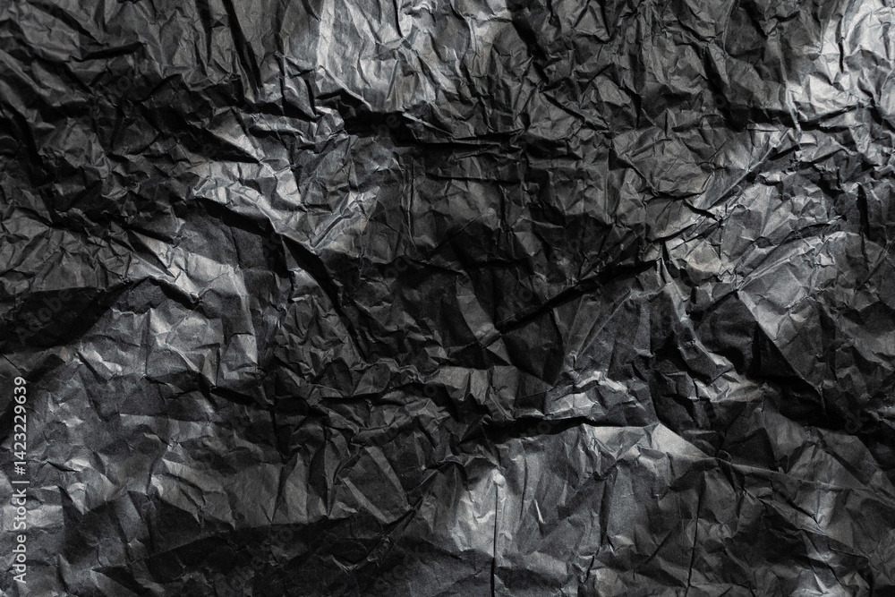 Texture of crumpled black wrapping paper with two sunray stripes on the surface
Texture of crumpled black wrapping paper with two sunray stripes on the surface
