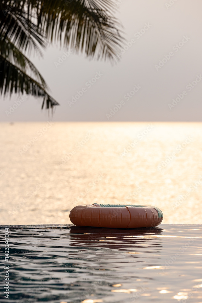 Inflatable circle floats on the pool at sunset, Surround tropical decor and greenery palm tree, Relaxing summer holiday, Inflatable ring float on water sunset view, Summer background vacation leisure.