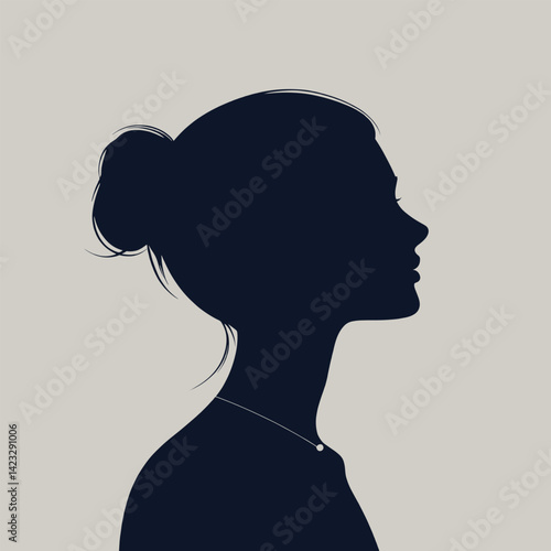 Silhouette of young female in profile with hair in bun and necklace