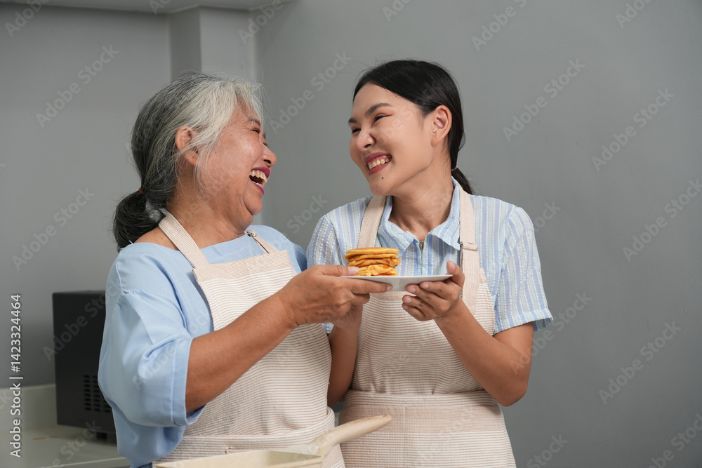 Two women, daughter cooking with elderly mother at home, happy mother's day, family day